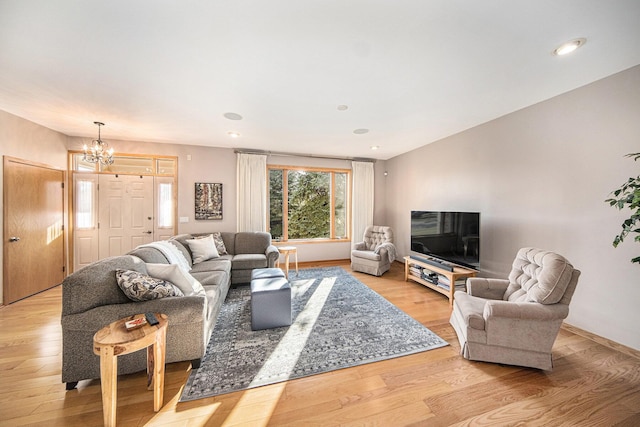 living room with a notable chandelier and light hardwood / wood-style floors