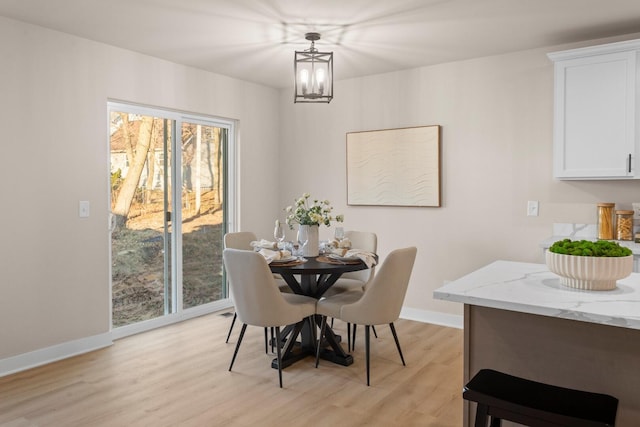 dining area with an inviting chandelier and light wood-type flooring