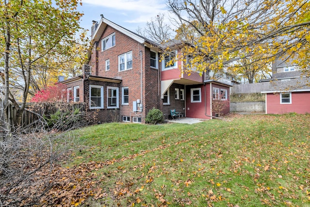 rear view of house with a lawn and a patio