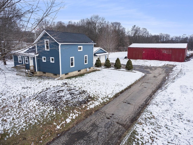 view of snow covered exterior with an outbuilding