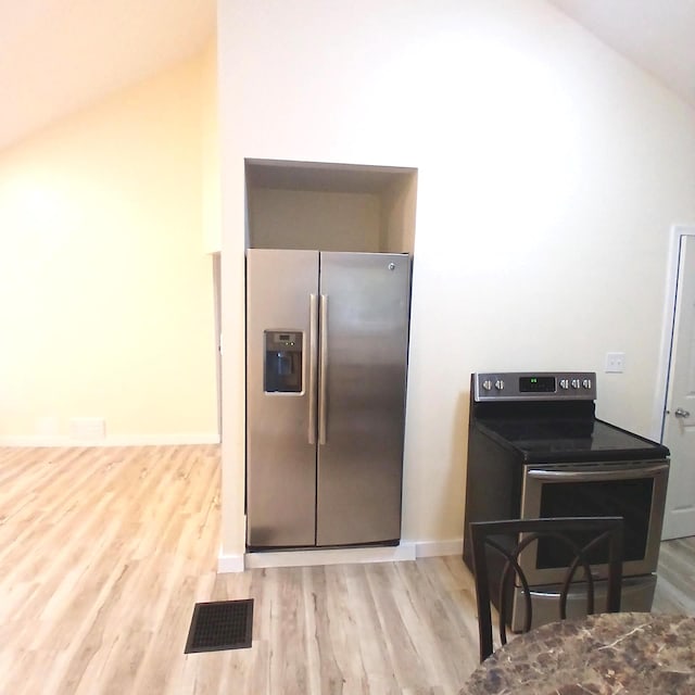 kitchen featuring stainless steel fridge, black / electric stove, and light hardwood / wood-style flooring