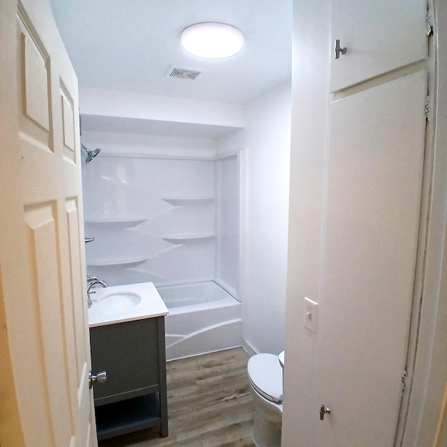 full bathroom featuring vanity, hardwood / wood-style flooring, toilet, and tub / shower combination