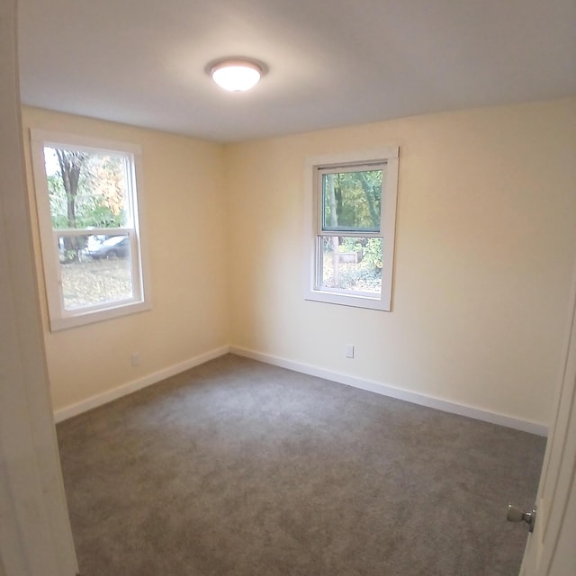 spare room with dark colored carpet