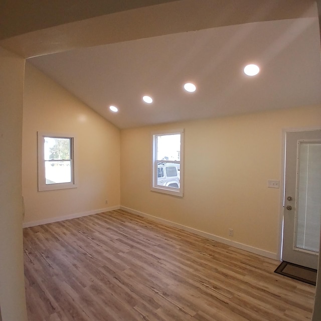 unfurnished room featuring hardwood / wood-style floors and vaulted ceiling