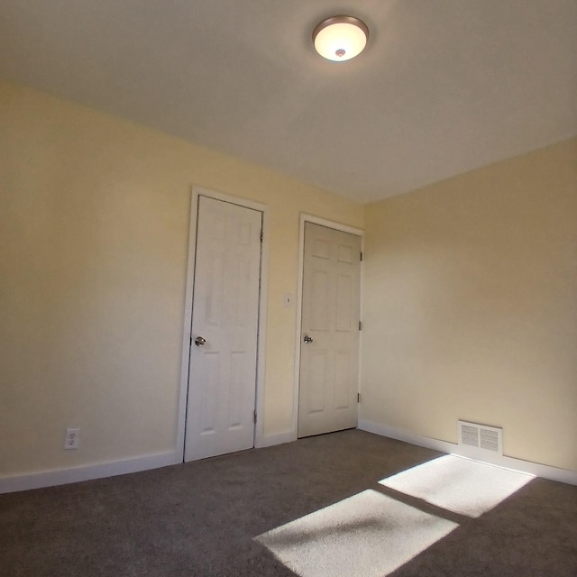 unfurnished bedroom featuring dark colored carpet