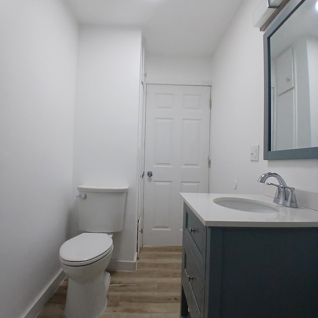 bathroom featuring hardwood / wood-style flooring, vanity, and toilet