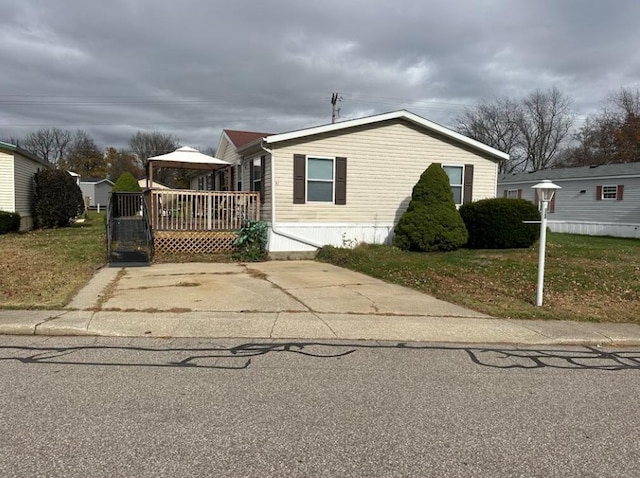 view of property exterior featuring a lawn, a deck, and a gazebo