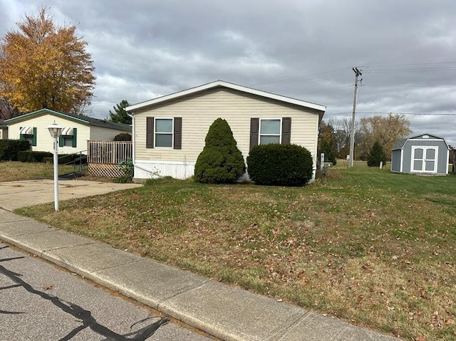 view of front of house featuring a shed, a front yard, and a wooden deck