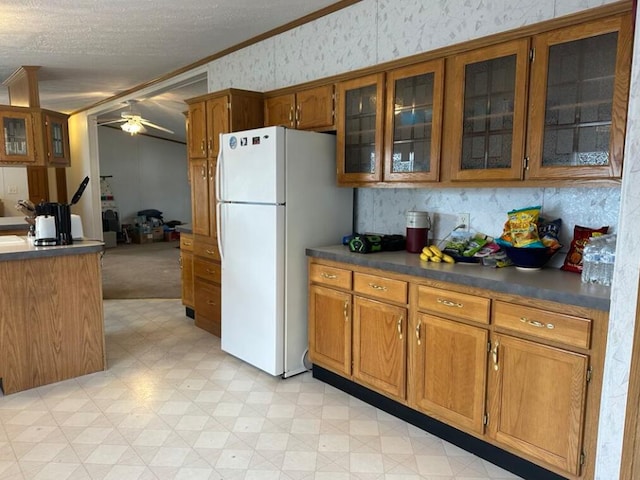 kitchen with ceiling fan, a textured ceiling, white fridge, and ornamental molding