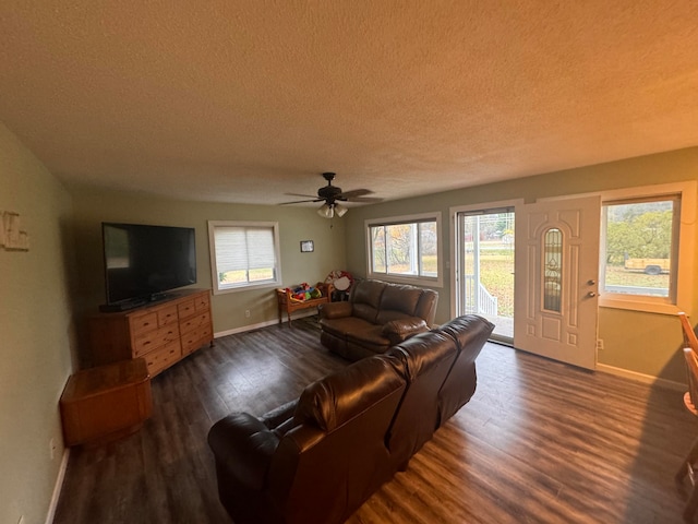 living room with dark hardwood / wood-style flooring, a textured ceiling, ceiling fan, and plenty of natural light