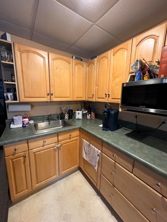 kitchen featuring a drop ceiling and sink