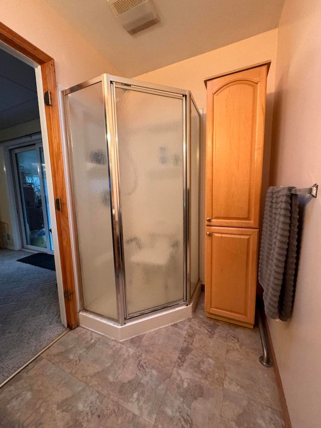 bathroom featuring a shower with shower door