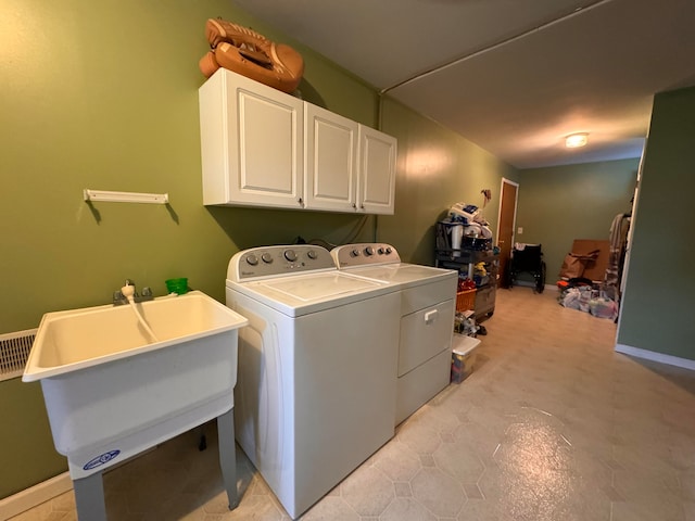 laundry area featuring cabinets, washer and clothes dryer, and sink