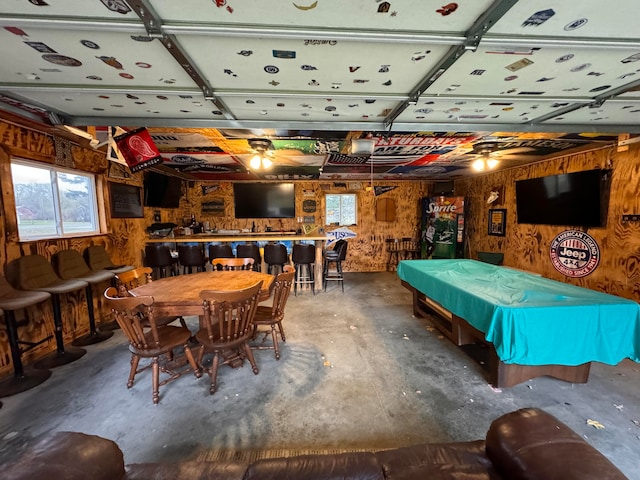 game room with wood walls, pool table, and concrete flooring