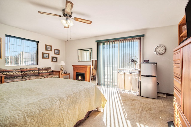 carpeted bedroom featuring ceiling fan and stainless steel fridge