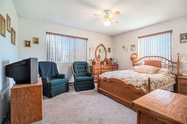 bedroom featuring light colored carpet, multiple windows, and ceiling fan