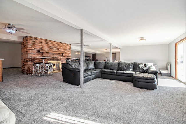 carpeted living room with a fireplace, ceiling fan, and beam ceiling