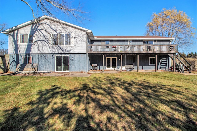 rear view of house featuring a wooden deck, a patio, and a yard