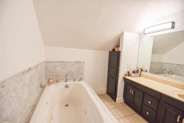 bathroom with tile patterned floors, a bathing tub, vanity, and lofted ceiling