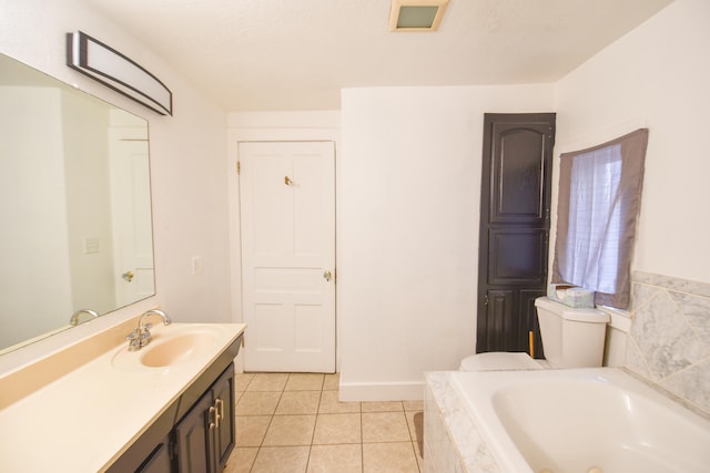 bathroom with toilet, vanity, tile patterned floors, and tiled tub