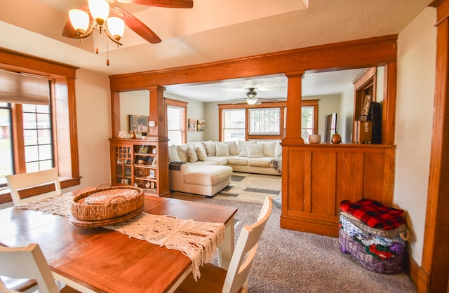 dining area featuring carpet, ornate columns, and ceiling fan