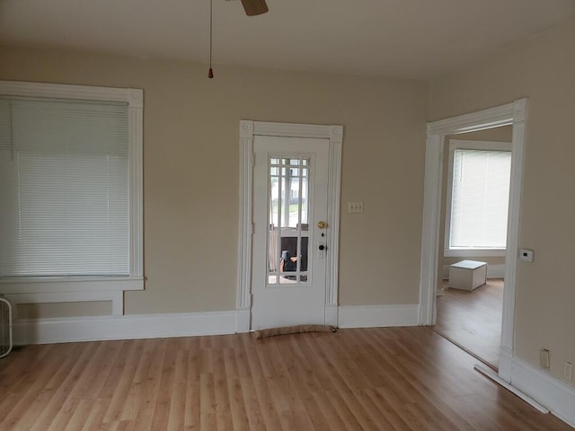 foyer entrance featuring light wood-type flooring, a wealth of natural light, and ceiling fan