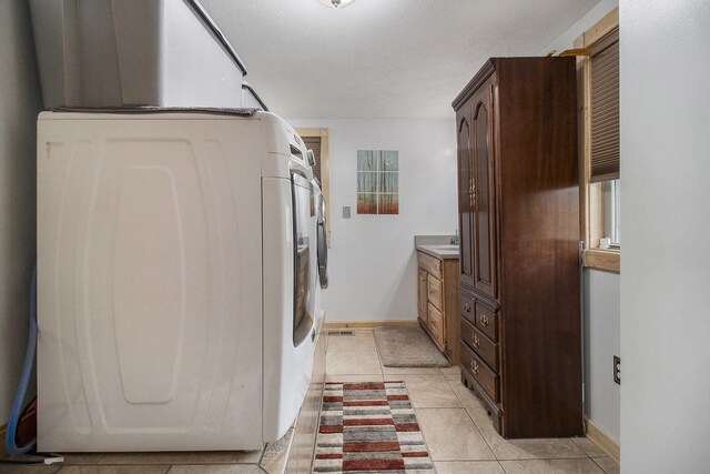 washroom with washer / clothes dryer and light tile patterned flooring