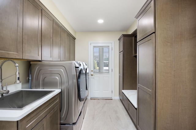 laundry area featuring cabinets, sink, and washing machine and clothes dryer