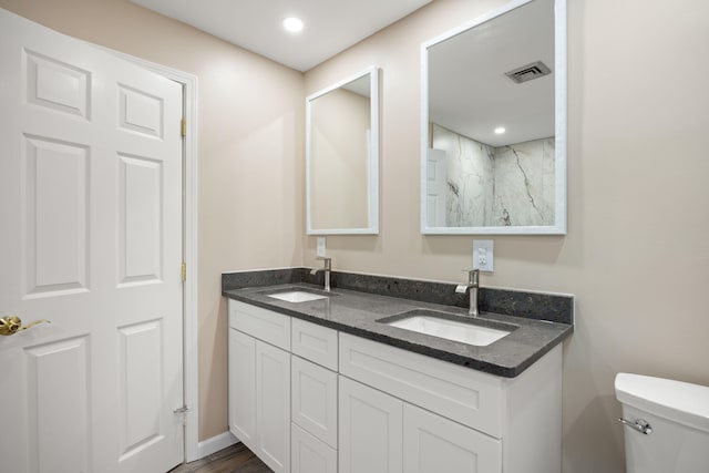 bathroom with hardwood / wood-style floors, vanity, and toilet