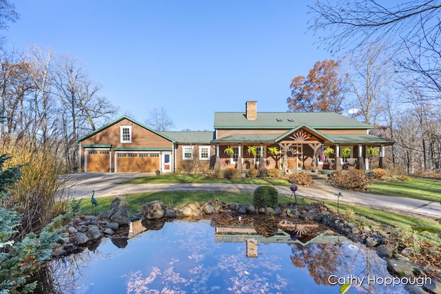 rear view of house featuring covered porch and a garage