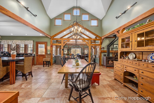 dining room featuring rail lighting, a chandelier, and lofted ceiling