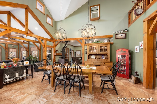 dining room with beam ceiling, high vaulted ceiling, a notable chandelier, and a wood stove