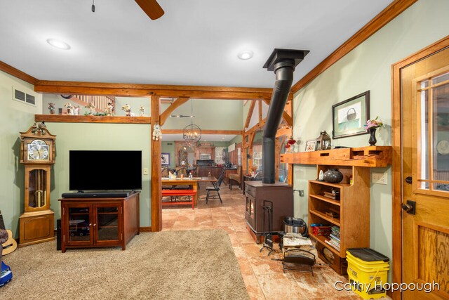 living room featuring a wood stove, ceiling fan, light colored carpet, and ornamental molding