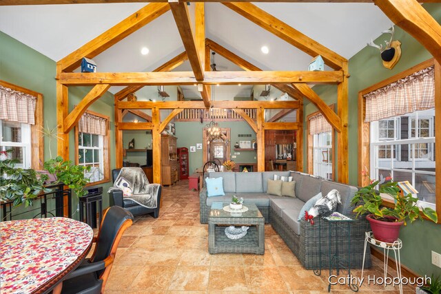 living room featuring beam ceiling and high vaulted ceiling