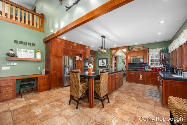 kitchen featuring appliances with stainless steel finishes, a kitchen island with sink, pendant lighting, and sink