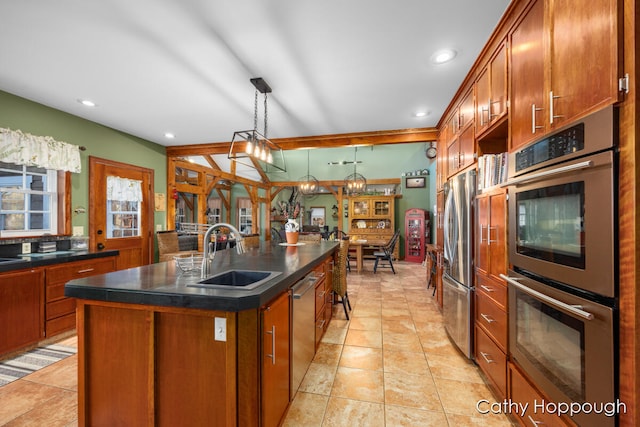 kitchen with a center island with sink, appliances with stainless steel finishes, pendant lighting, and sink