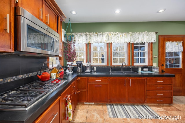 kitchen featuring light tile patterned floors, stainless steel appliances, and sink