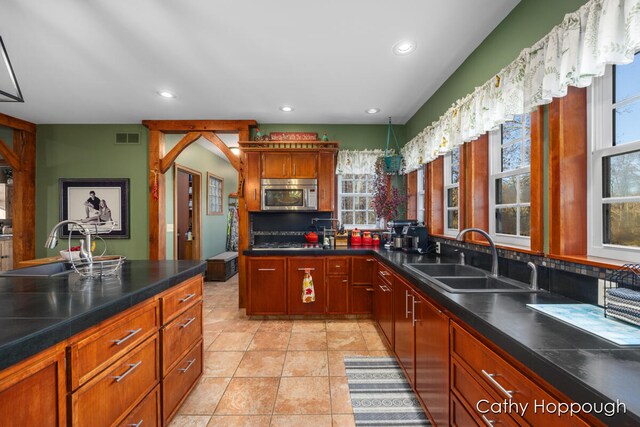 kitchen featuring light tile patterned floors, backsplash, and sink