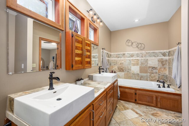 bathroom with vanity, a wealth of natural light, and a bathing tub