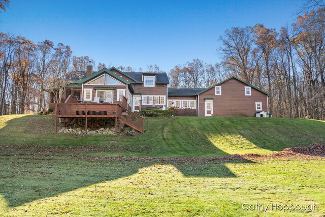 rear view of house with a yard and a deck