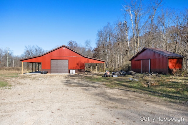 view of outdoor structure with a carport and a garage