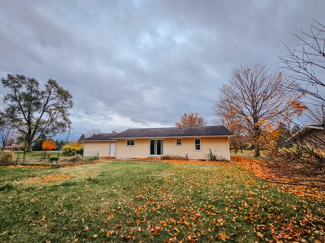 rear view of property with a lawn