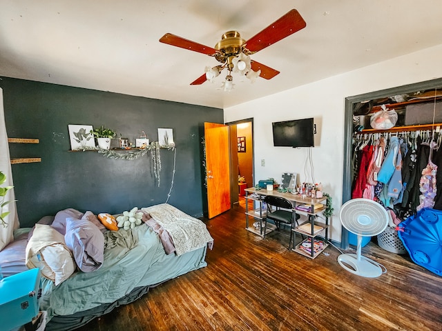 bedroom with dark wood-type flooring, ceiling fan, and a closet