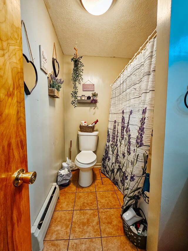 bathroom featuring tile patterned flooring, a baseboard radiator, toilet, and a textured ceiling