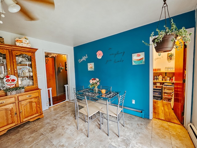 dining space with ceiling fan, baseboard heating, and light hardwood / wood-style floors