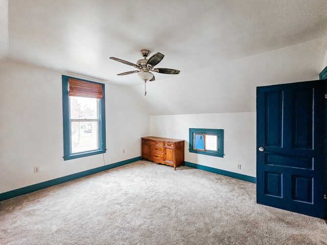 additional living space featuring vaulted ceiling, light colored carpet, and ceiling fan