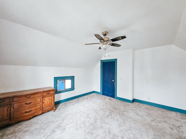 additional living space with ceiling fan, light colored carpet, and vaulted ceiling