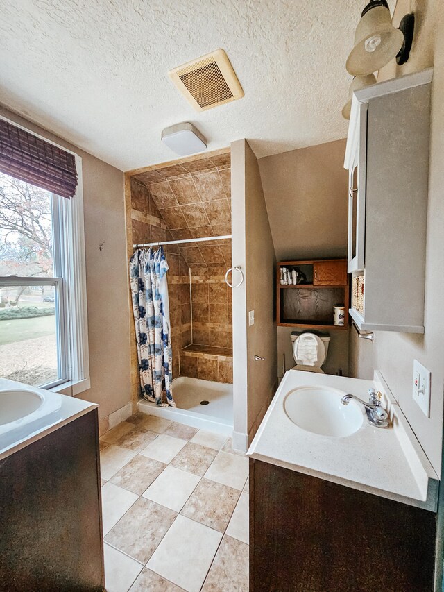 bathroom with vanity, a textured ceiling, and curtained shower