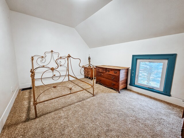 carpeted bedroom featuring lofted ceiling