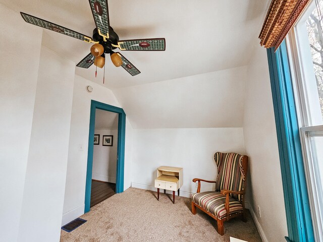 sitting room with ceiling fan, vaulted ceiling, and carpet